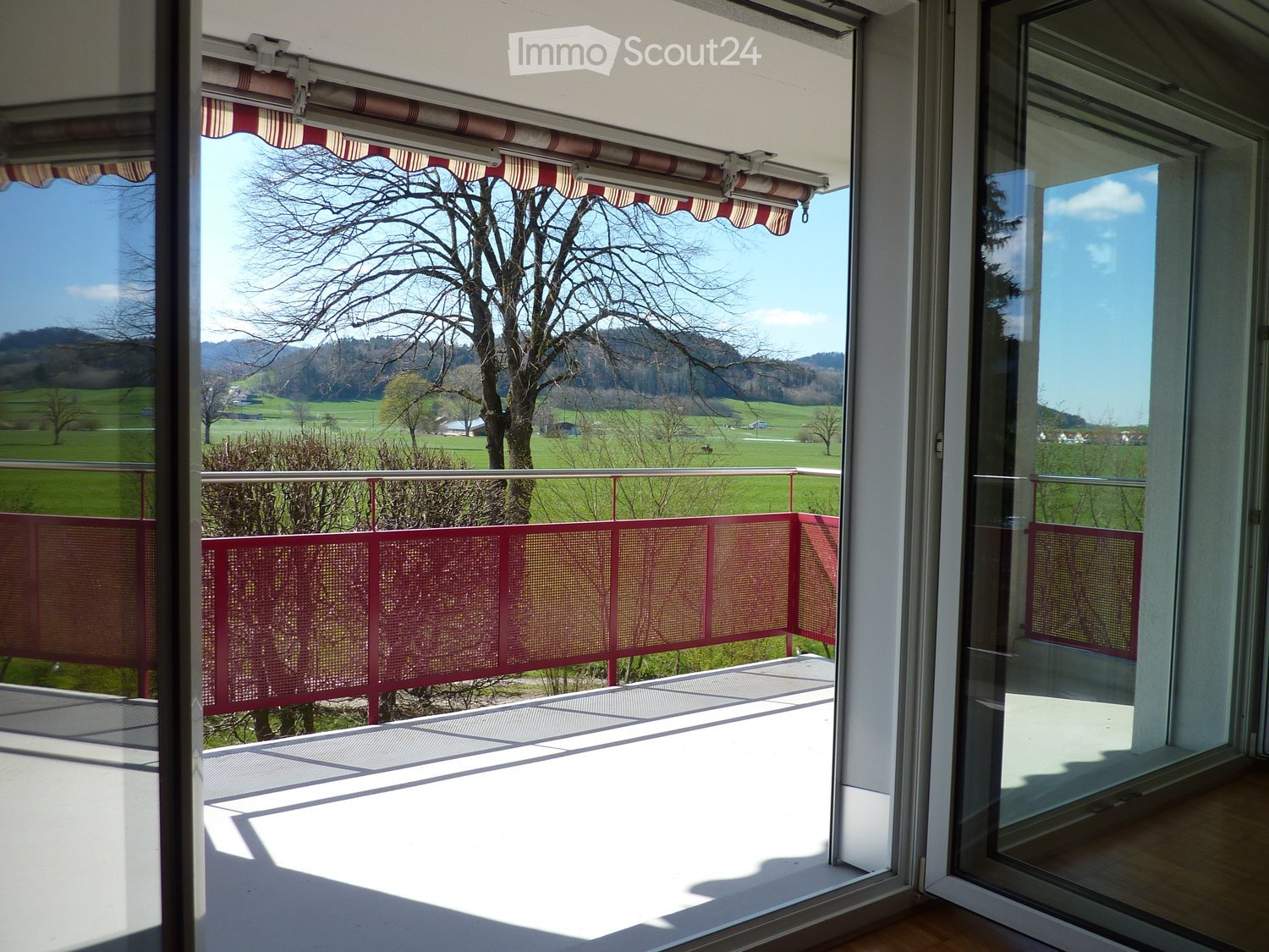 large balcony, glass doors, railings, wide view of the exterior