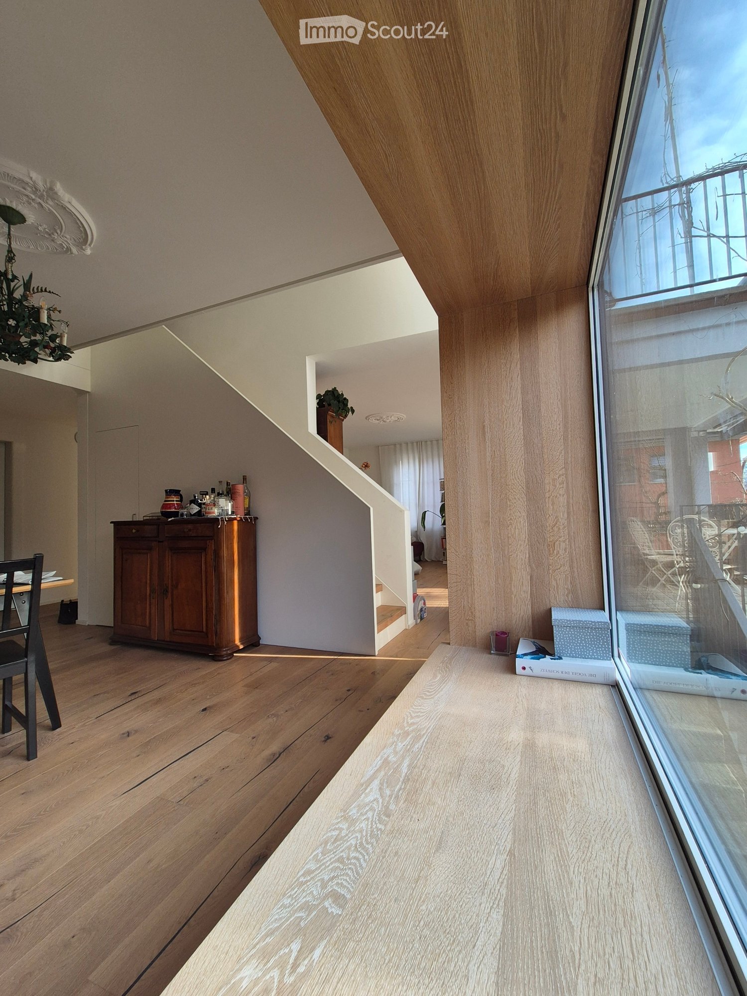wooden floor, wooden cupboard, staircase, chandelier, window with balcony view