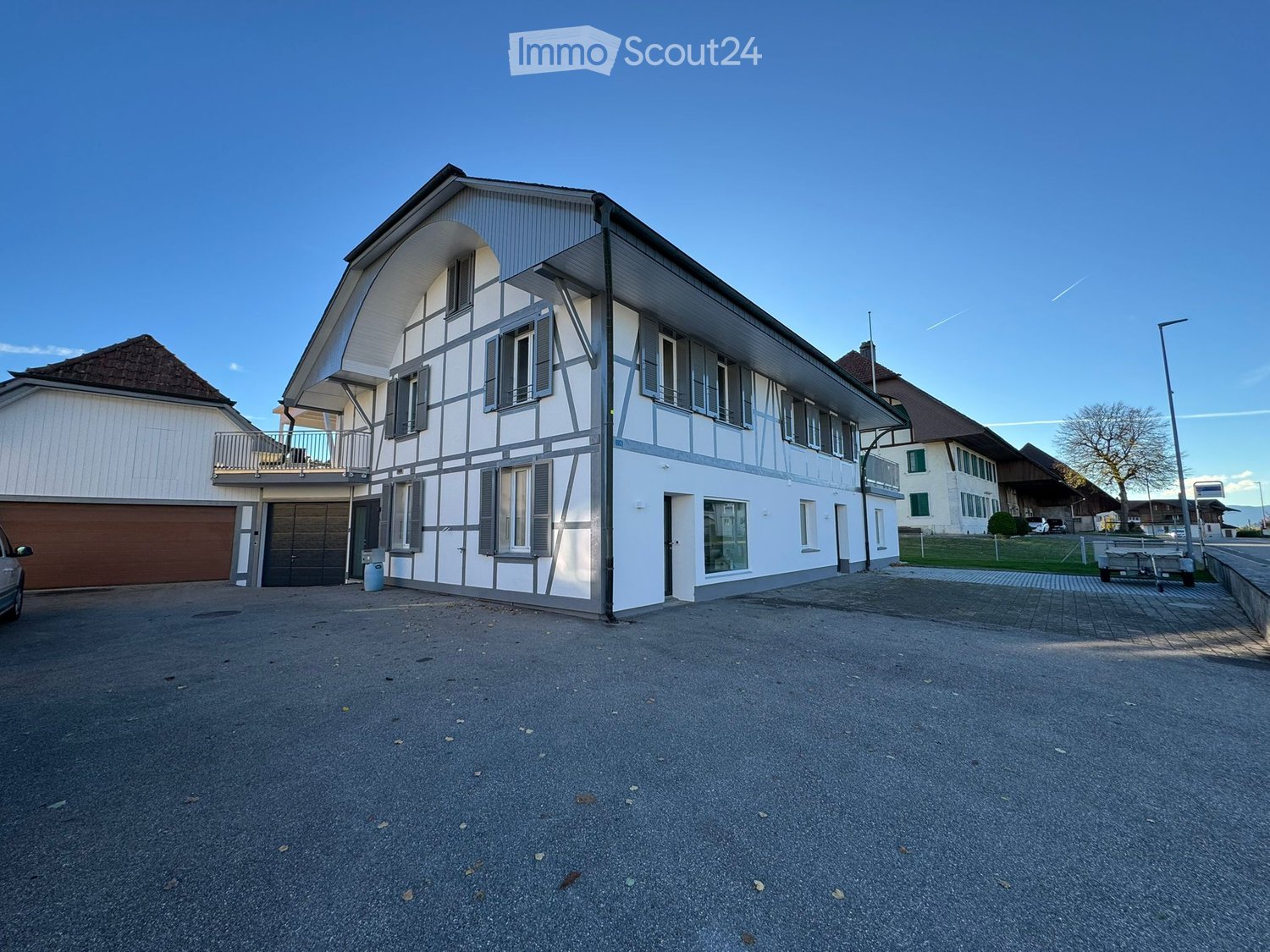 2 story house, white walls, brown roof, double garage, empty parking lot