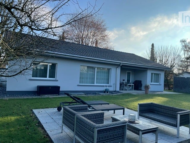 modern white house, large lawn, large patio, garden furniture, lounge chairs, garden table