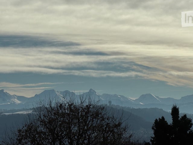 Snow capped mountains under a cloudy sky