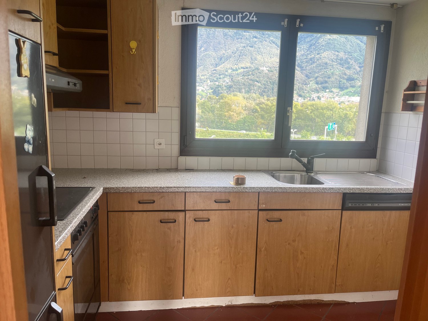 wooden cabinets, tile backsplash, granite countertop, stainless steel sink, oven, dishwasher, electric range, refrigerator, power outlet, large window with mountain view