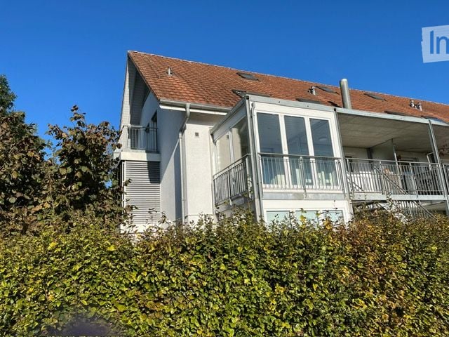 two story house, brick roof, glass balcony, glass windows, shrubs in front