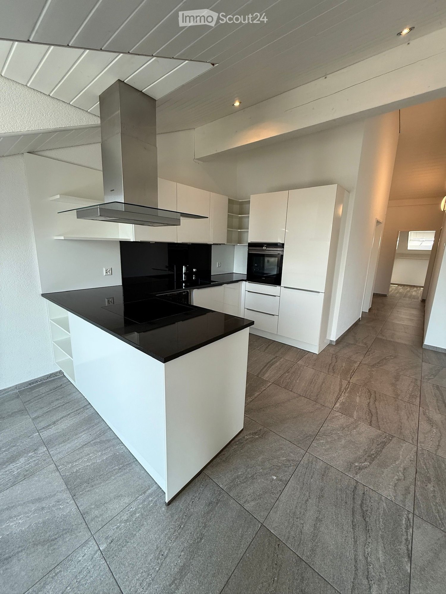 modern kitchen, white cabinets, black granite countertops, stainless steel exhaust hood, tiled floor, open plan