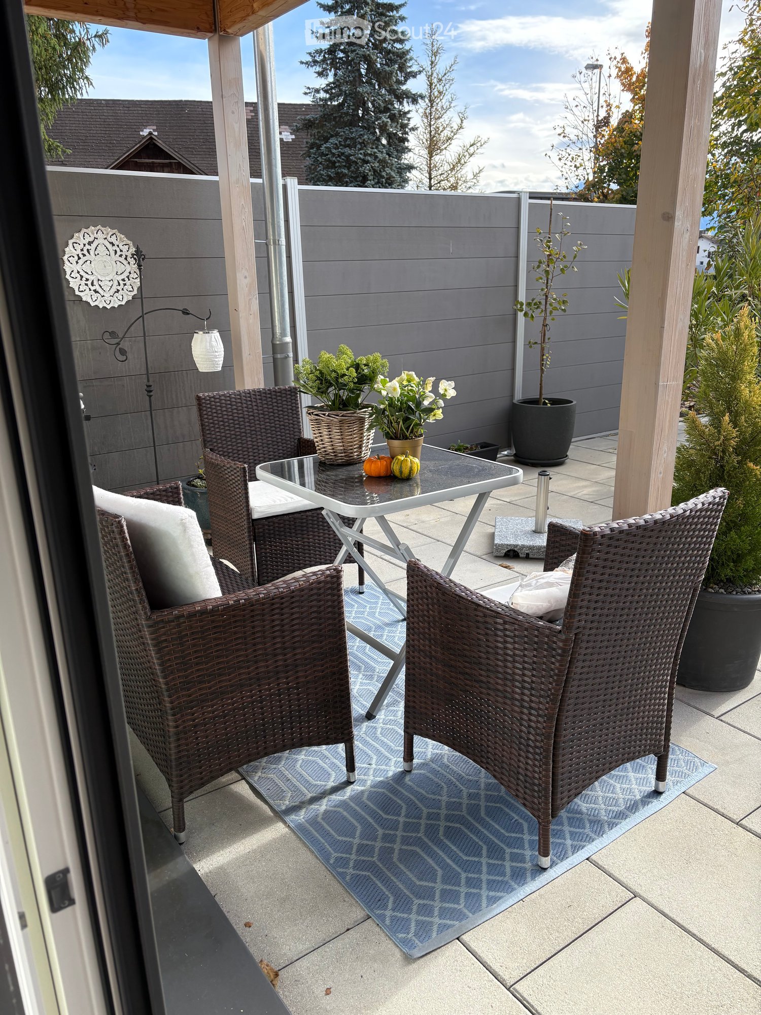 Patio with chairs, table, plants, pillows, and decorative items