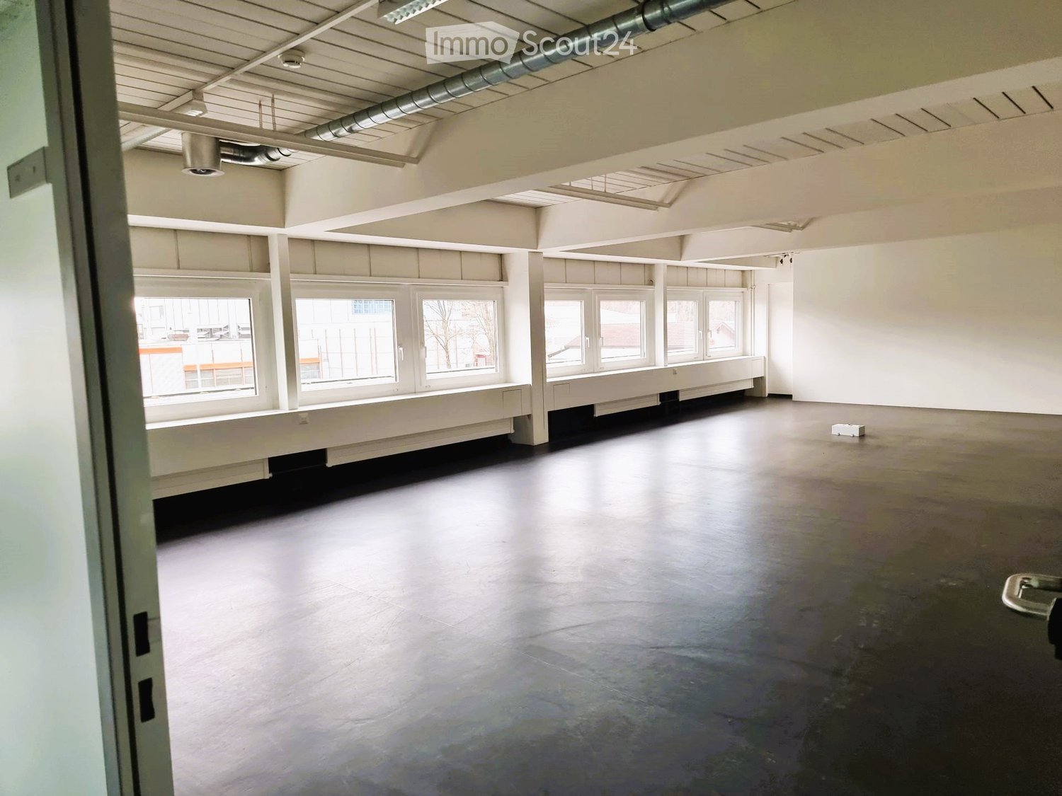 empty room, large windows, gray floors, white walls, long benches