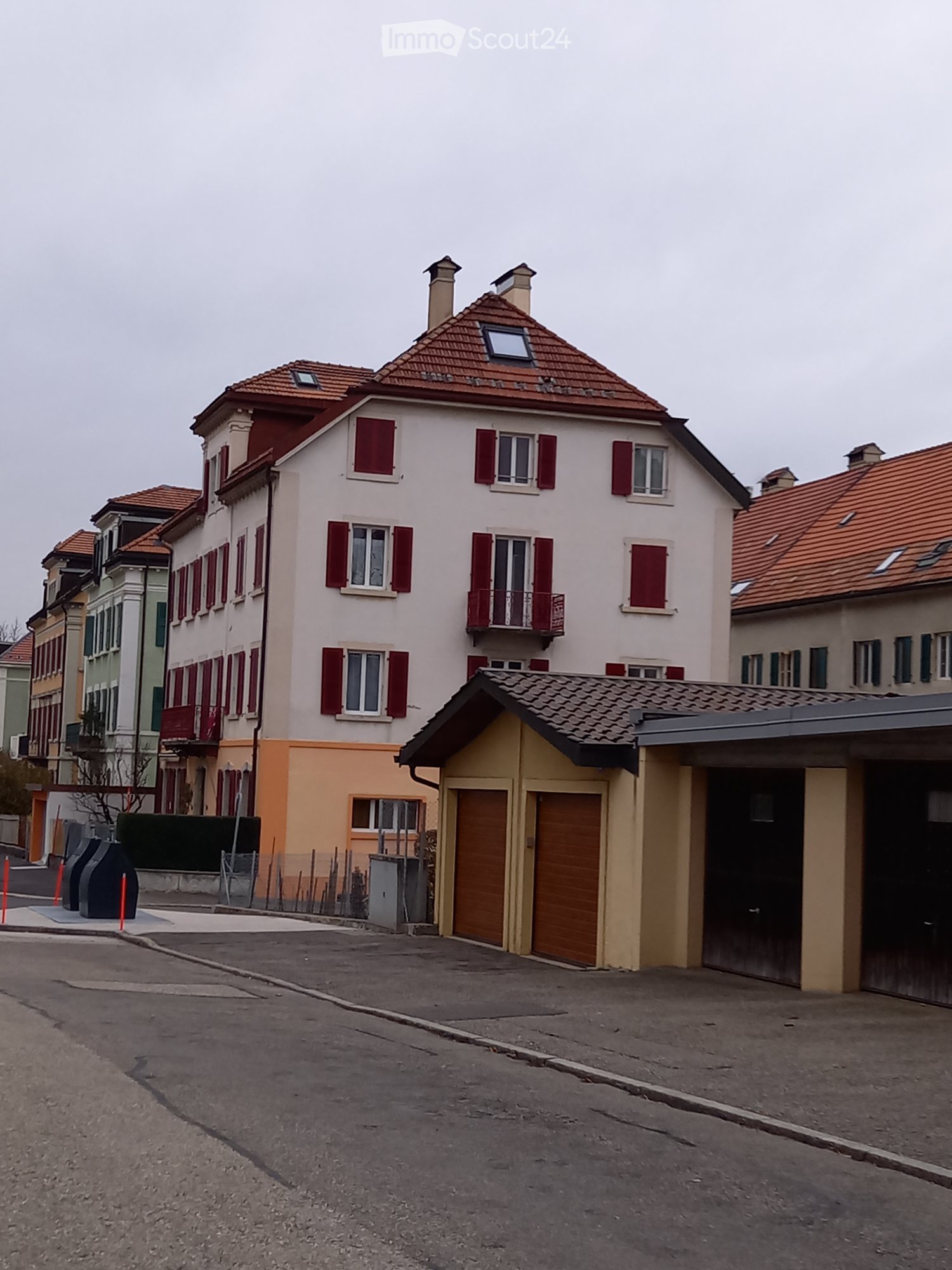 3-story building, red roof, red shutters, balconies, attached garage