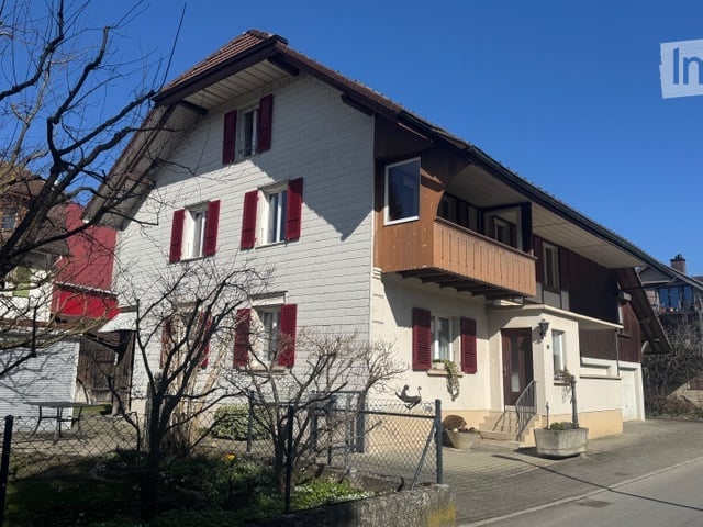 2 story house, white and brown color, red shutters, balcony, fenced yard, red rooftop