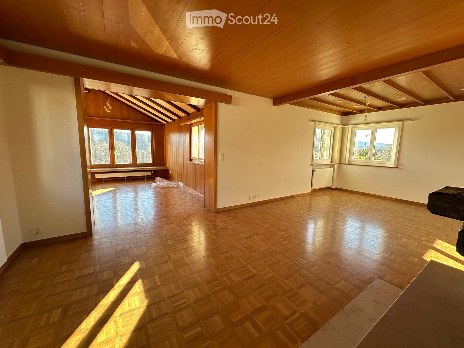 Open floor plan, wooden floor, large windows, wooden ceiling, radiators, natural light