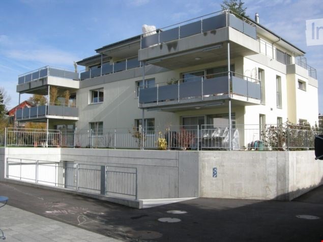 Multi-storey building, white exterior, metal railings, balconies on multiple levels