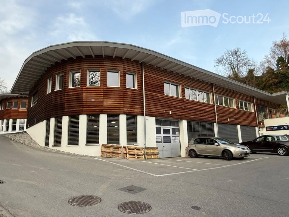curved design, brown wooden exterior, windows, 2 garages, cars parked in front