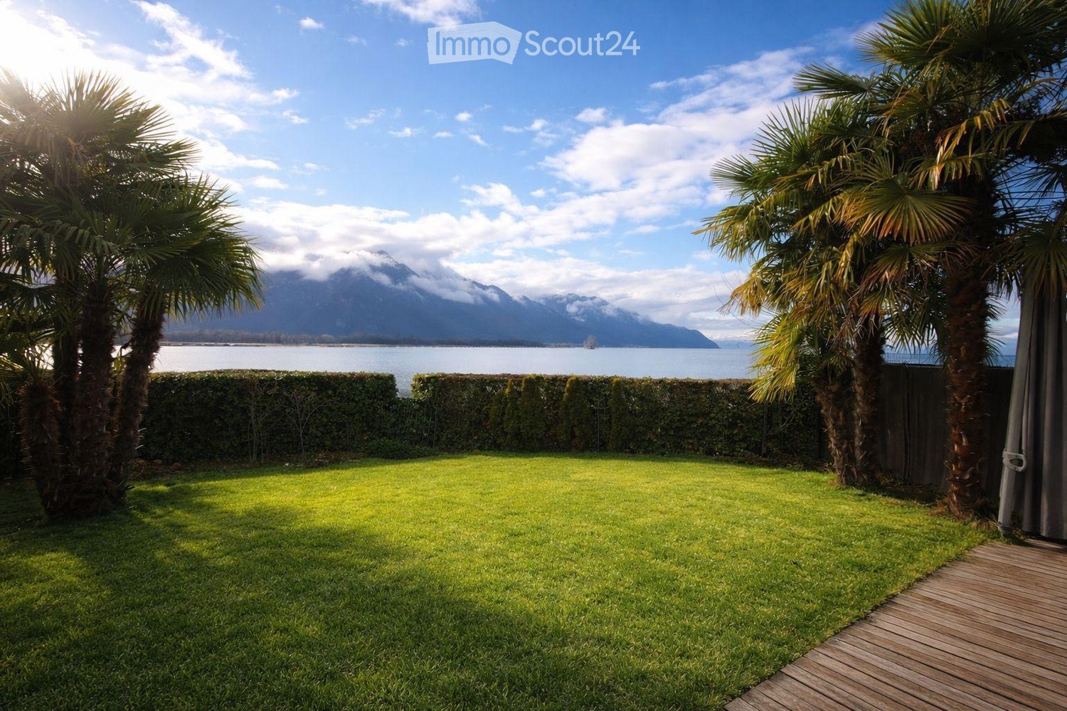 well-maintained lawn, hedges, palm trees, wooden deck, view of the lake and mountains