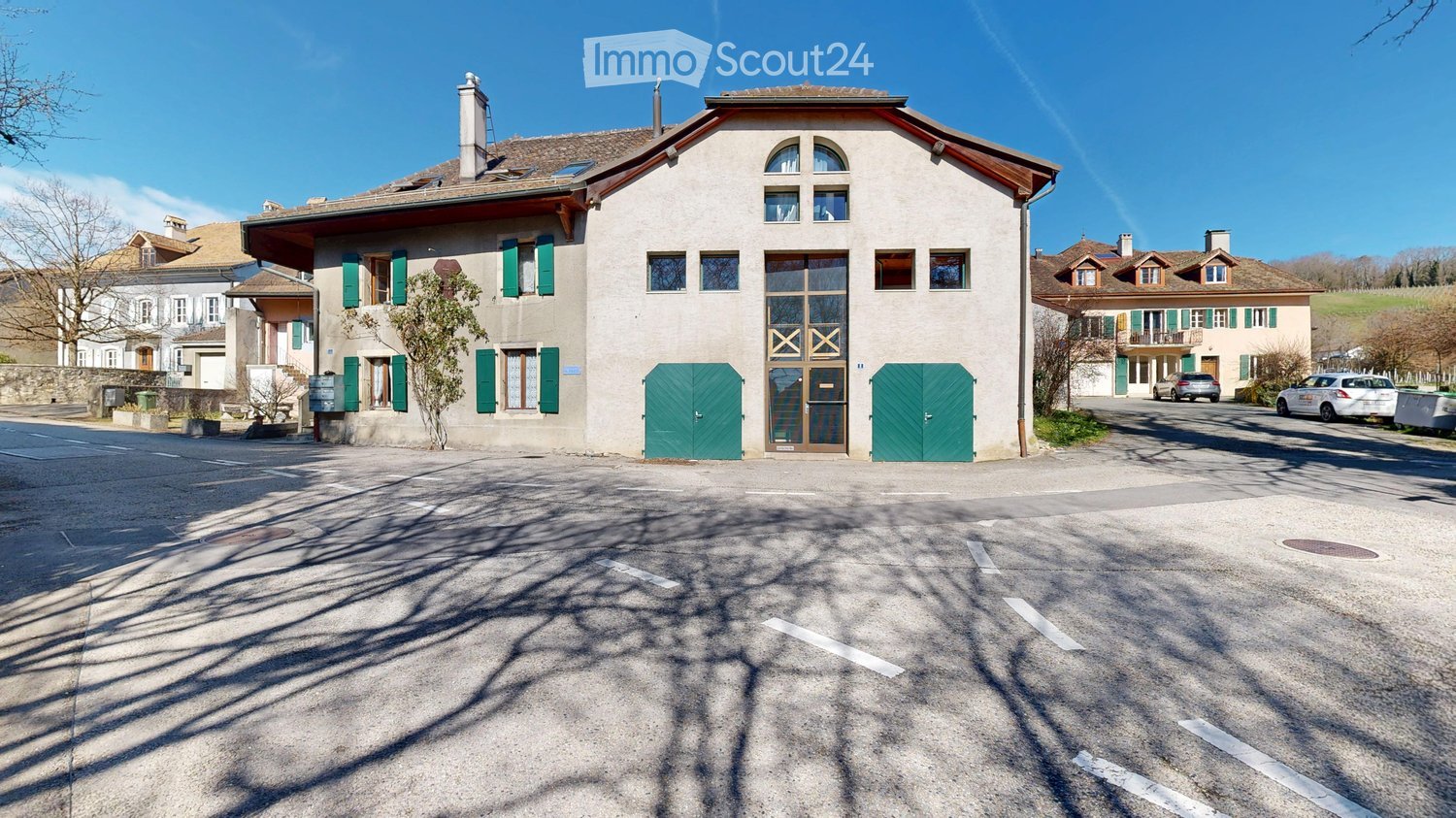 2 story house, white walls, green shutters, 2 green doors, 2 cars parked in front