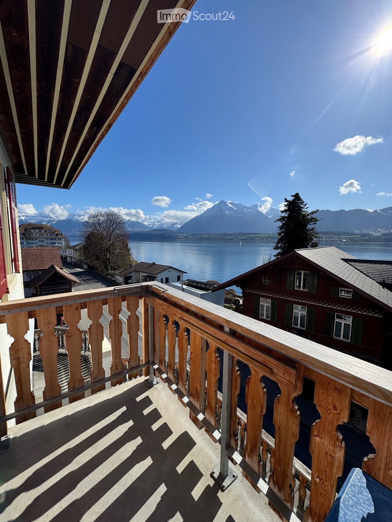 wooden balcony railing, wooden floor, view of a lake and mountains