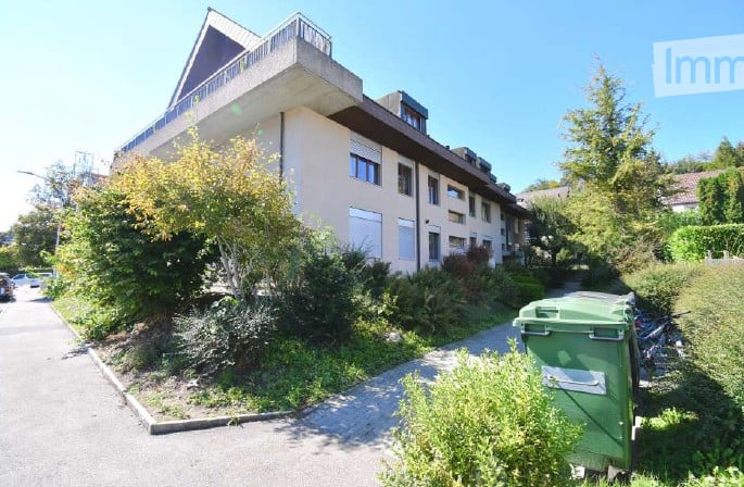 3 story apartment building, balcony, concrete fence, green trash bin, street light
