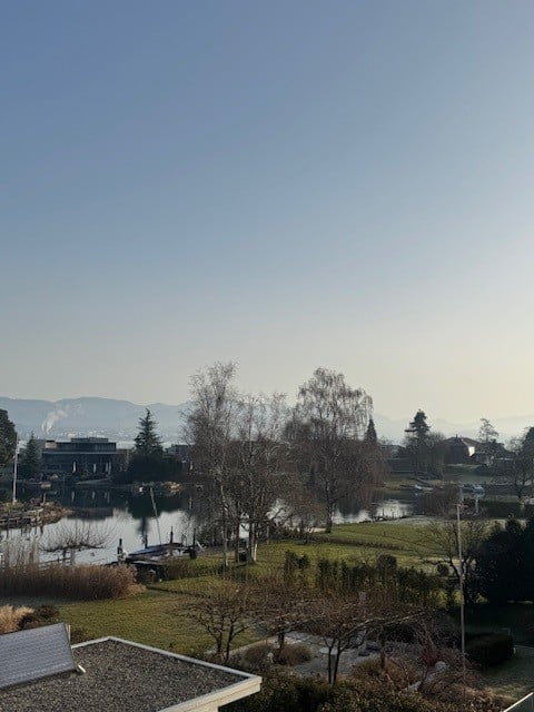 lake, trees, mountains, clear sky, buildings in the distance