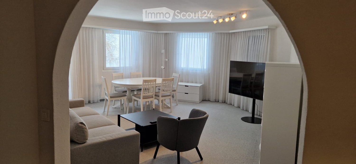 living room with couch, table, chairs, TV, and a dining table with chairs