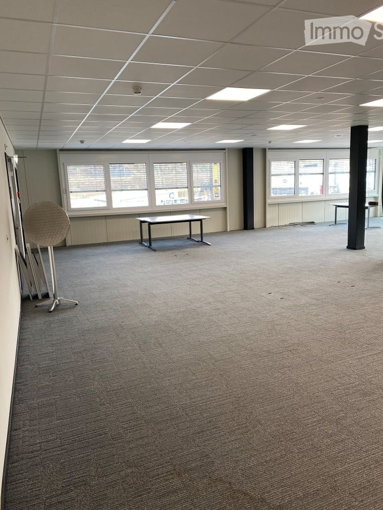 empty room, carpeted floor, two tables, windows with blinds, ceiling lights