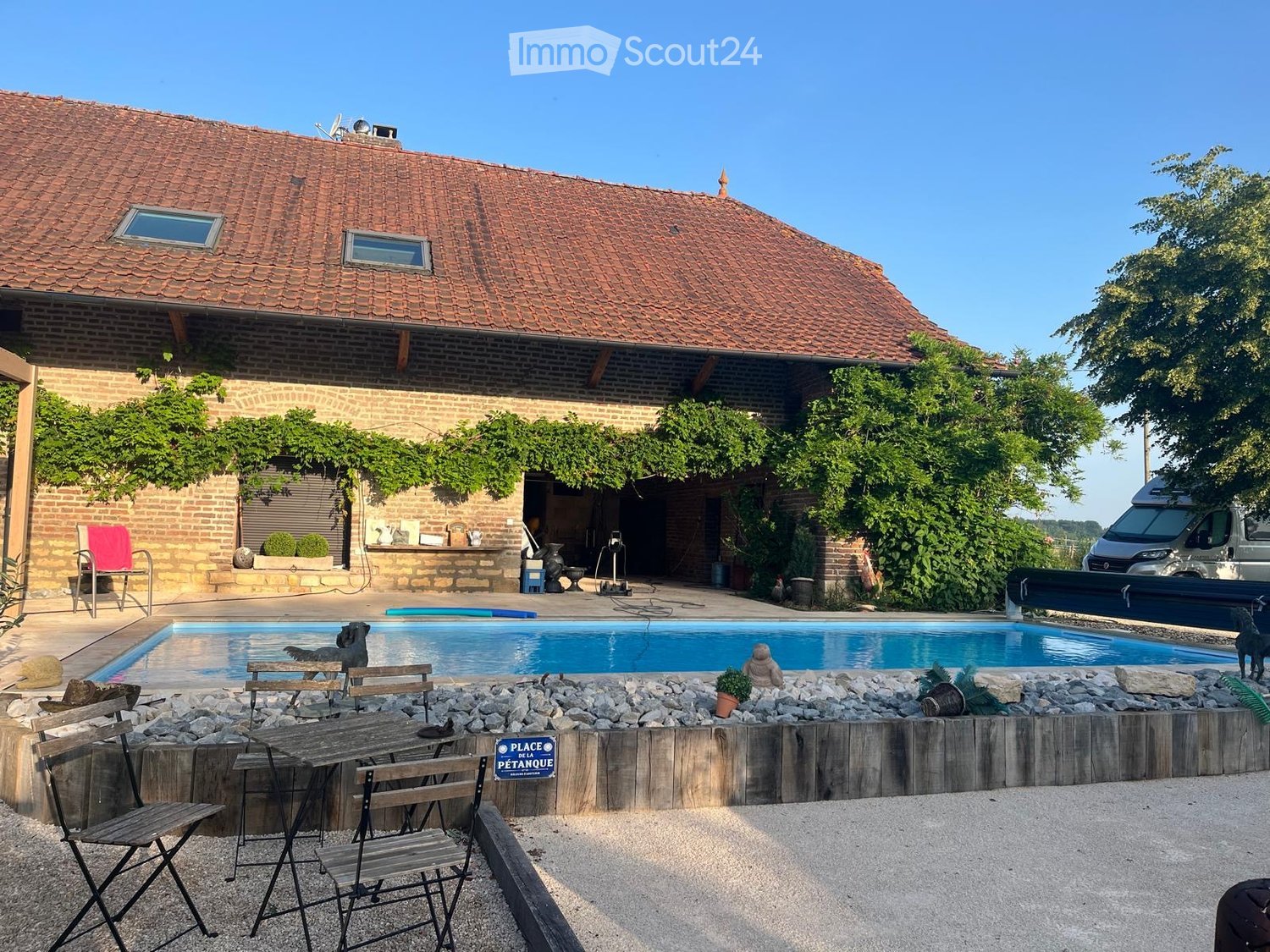 Brick house, red roof, swimming pool, garden, outdoor seating area, van parked