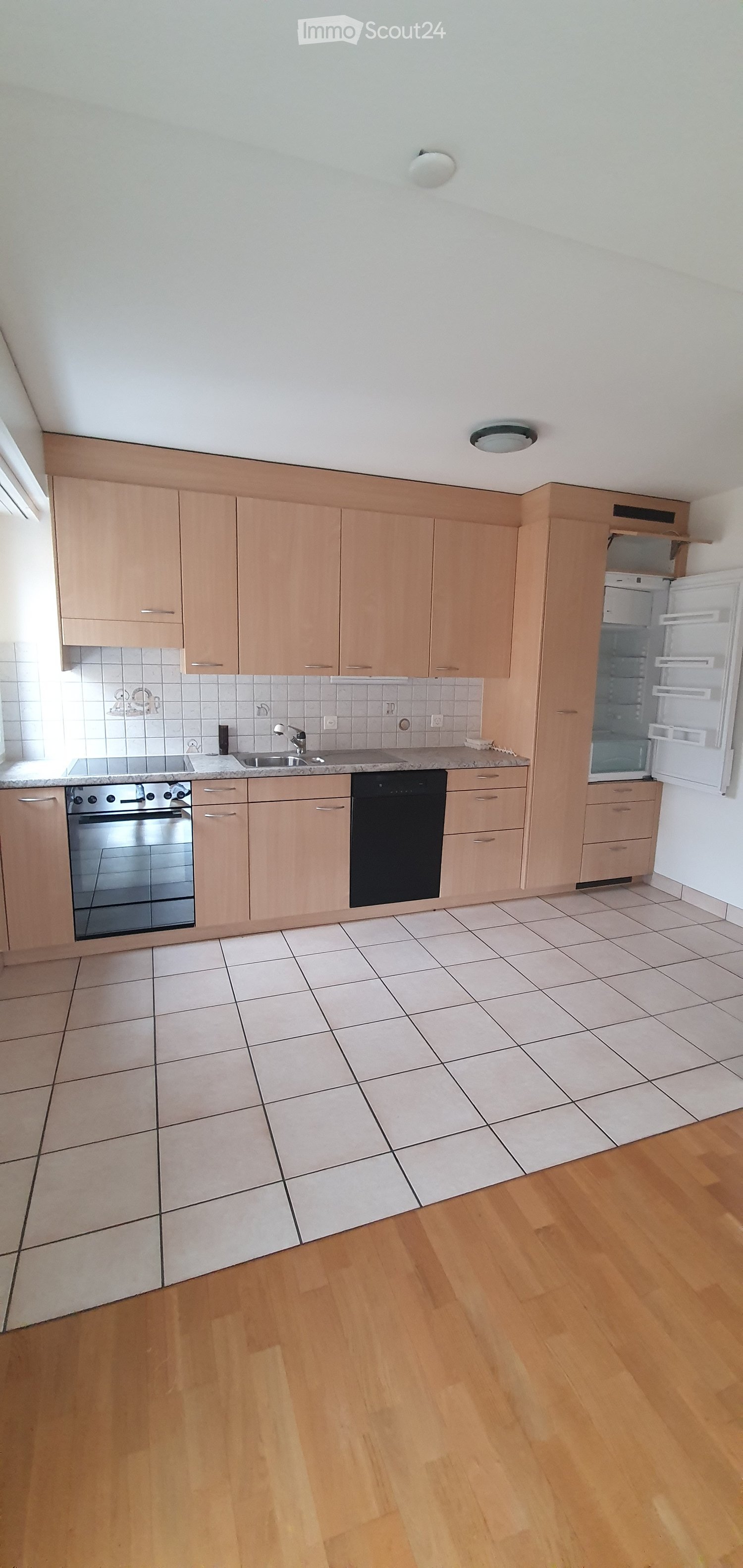 modern kitchen, wooden cabinets, white tiles, stainless steel appliances, open refrigerator