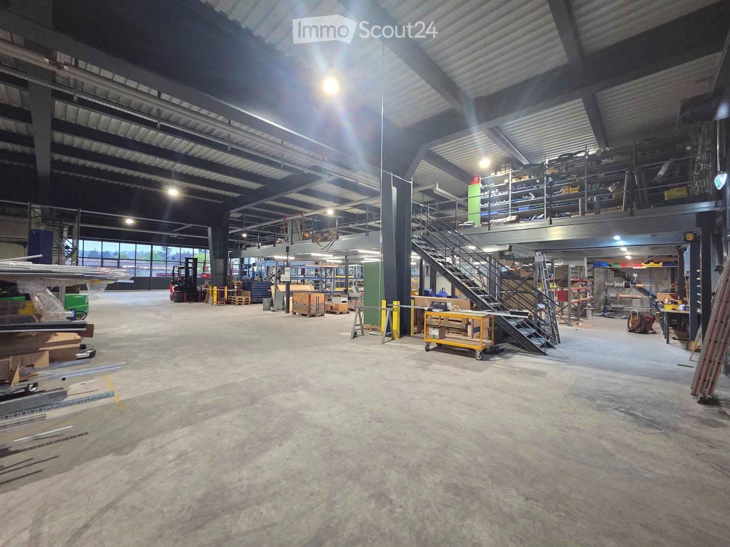 large open space, metal beams, mezzanine, forklift, storage boxes, shelves, yellow caution tape