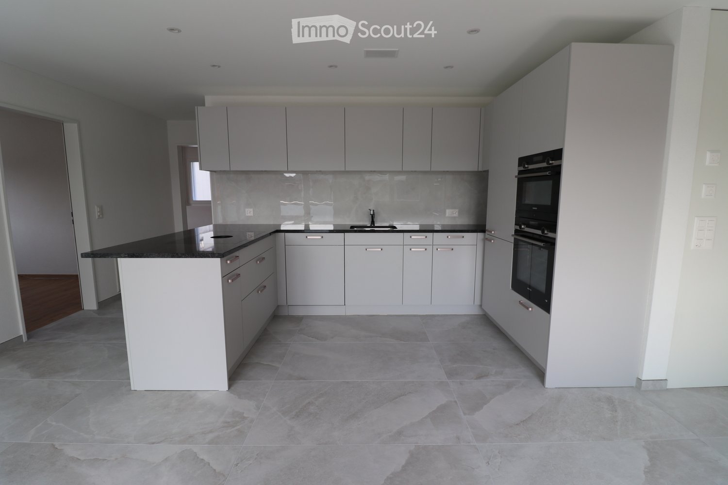 modern kitchen, white cabinets, black countertops, integrated appliances, tiled flooring