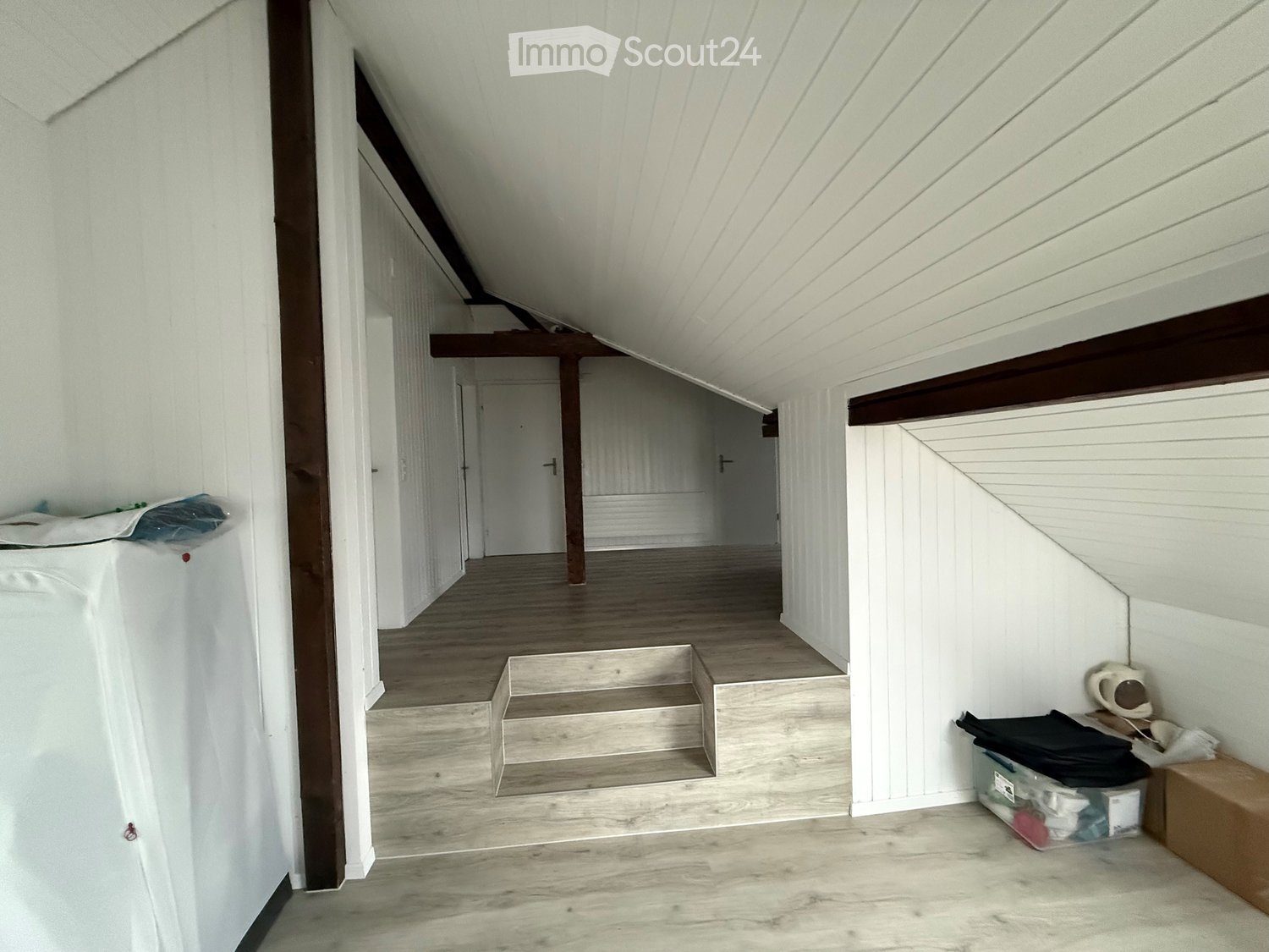 empty attic with wooden steps and ceiling, white walls