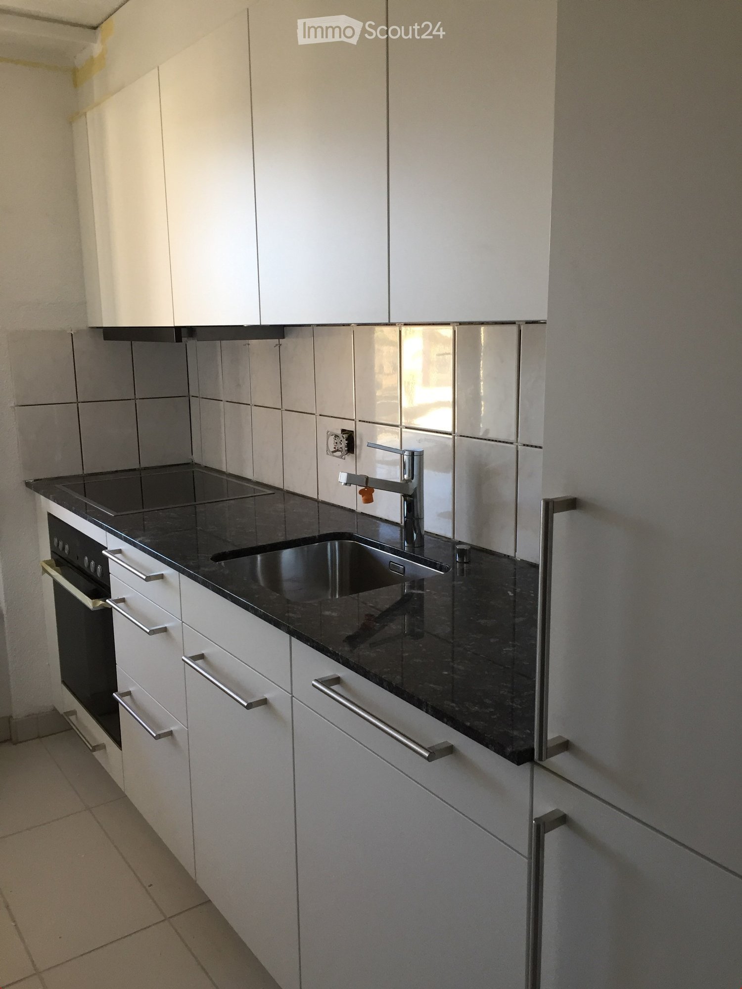 modern kitchen with white cabinets, black granite countertop, stainless steel sink, faucet, built-in oven, dishwasher