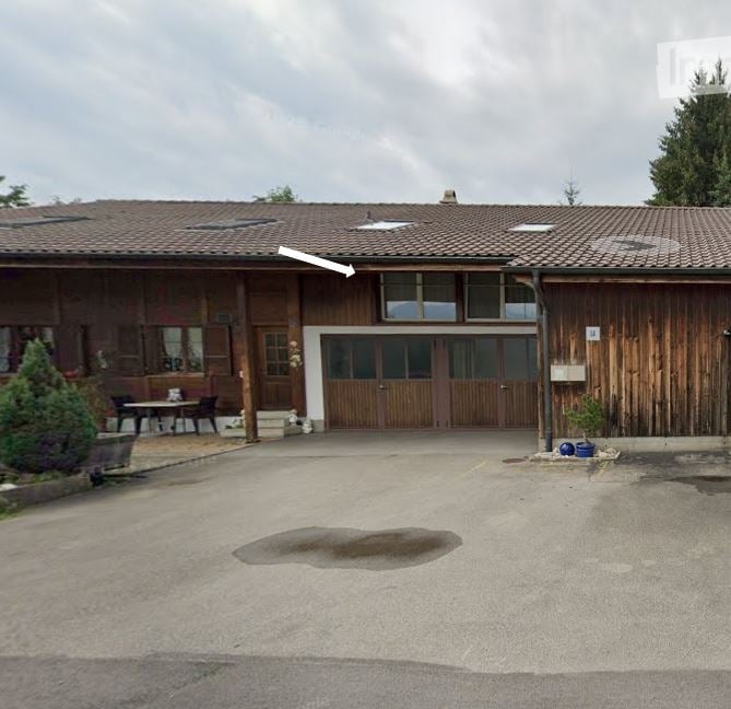 wooden building, brown roof, large windows, parking lot in front
