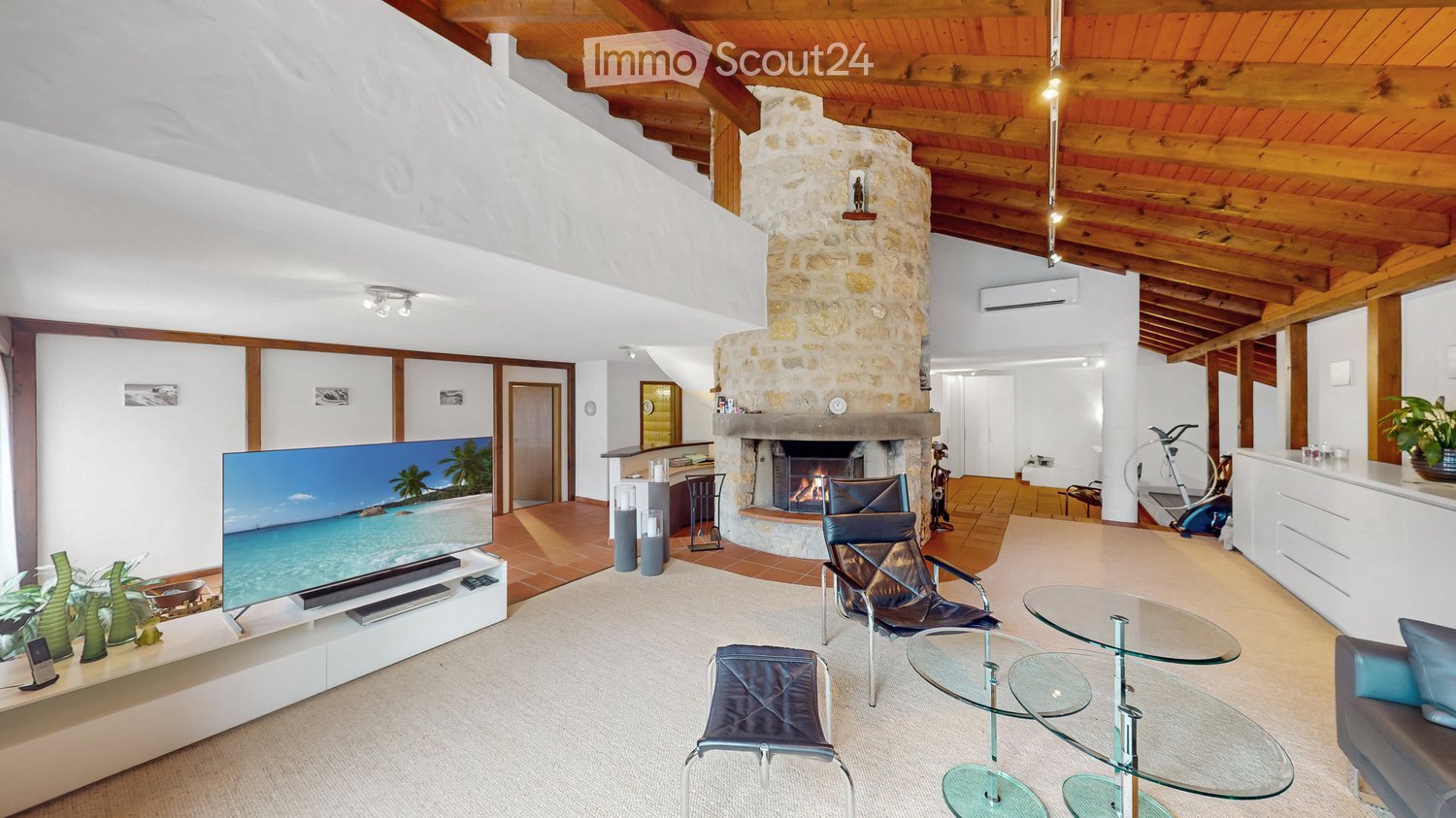 wooden ceiling, fireplace, large flat screen TV, leather chairs, glass tables, carpet