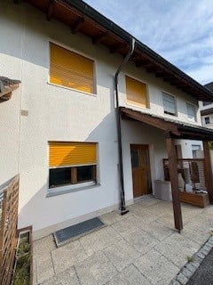 white house, yellow shutters, wooden door, wooden awning, paved entrance