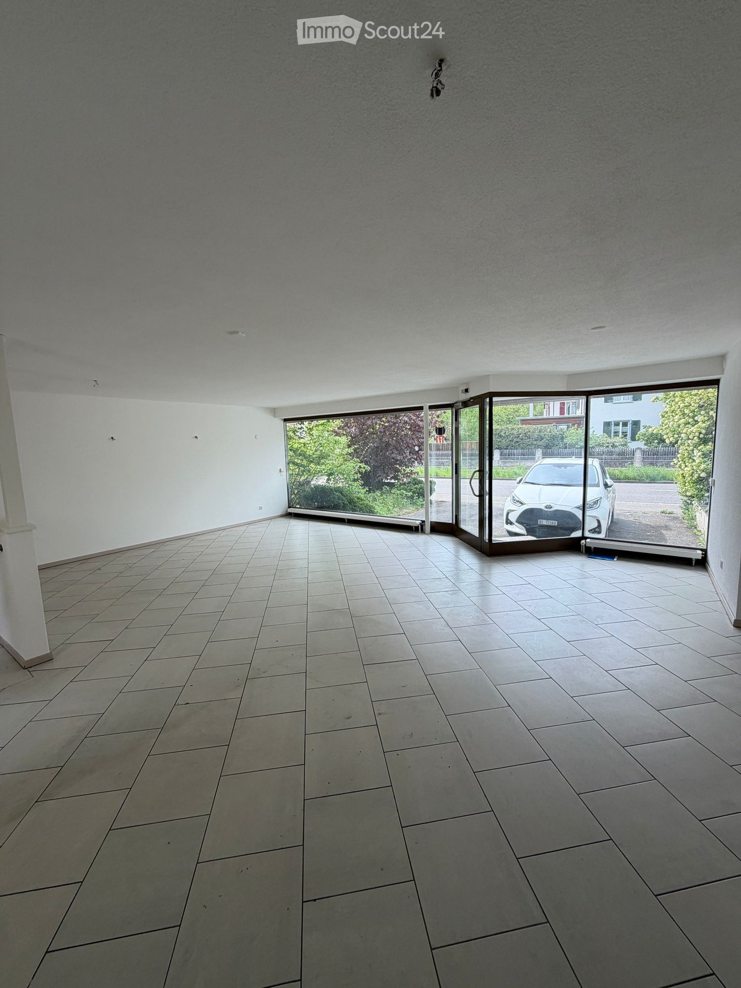 empty room, large windows, tiled floor, sliding doors, car parked outside
