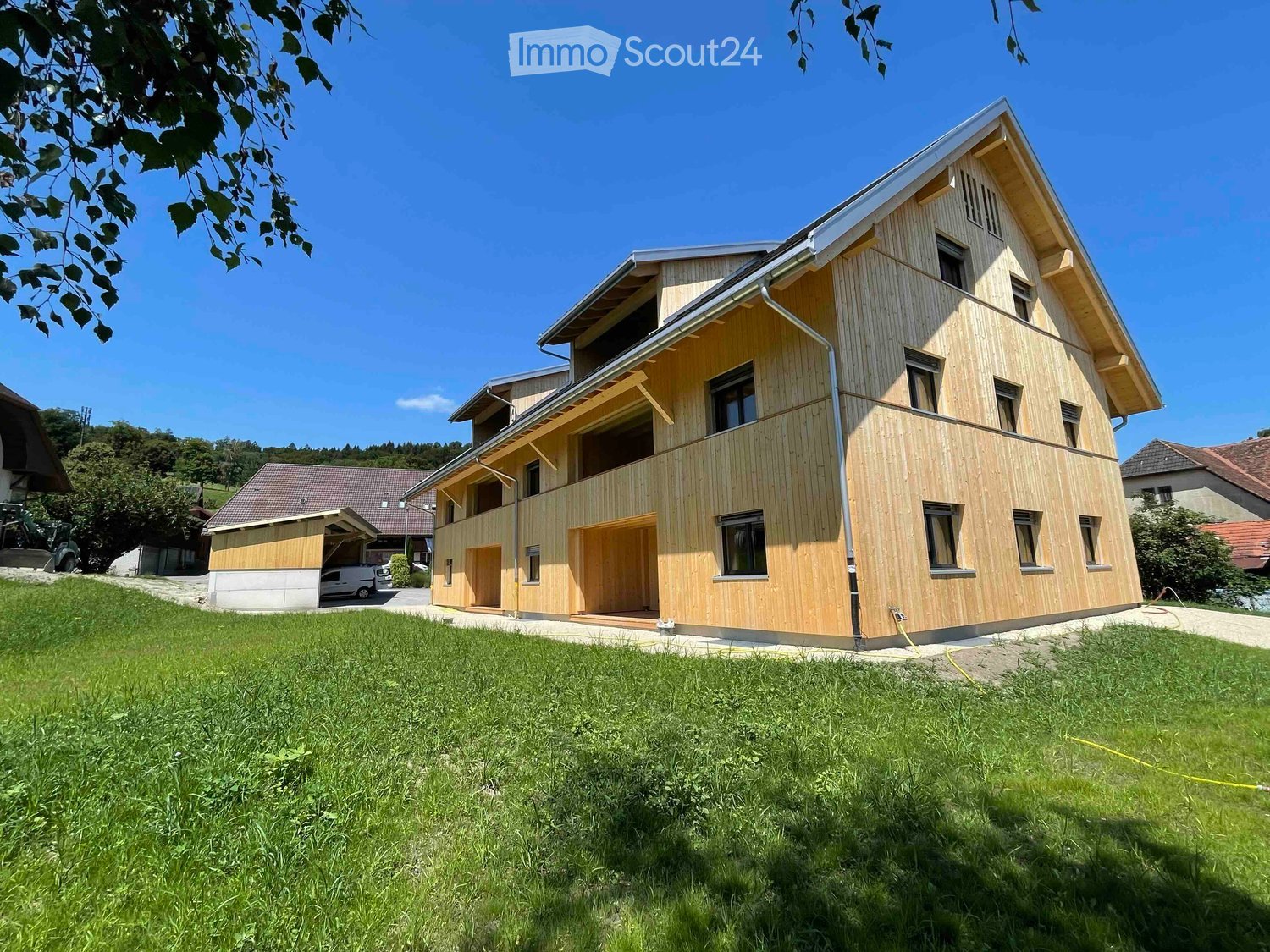 Modern house with wooden exterior, multiple windows, garage attached, two stories
