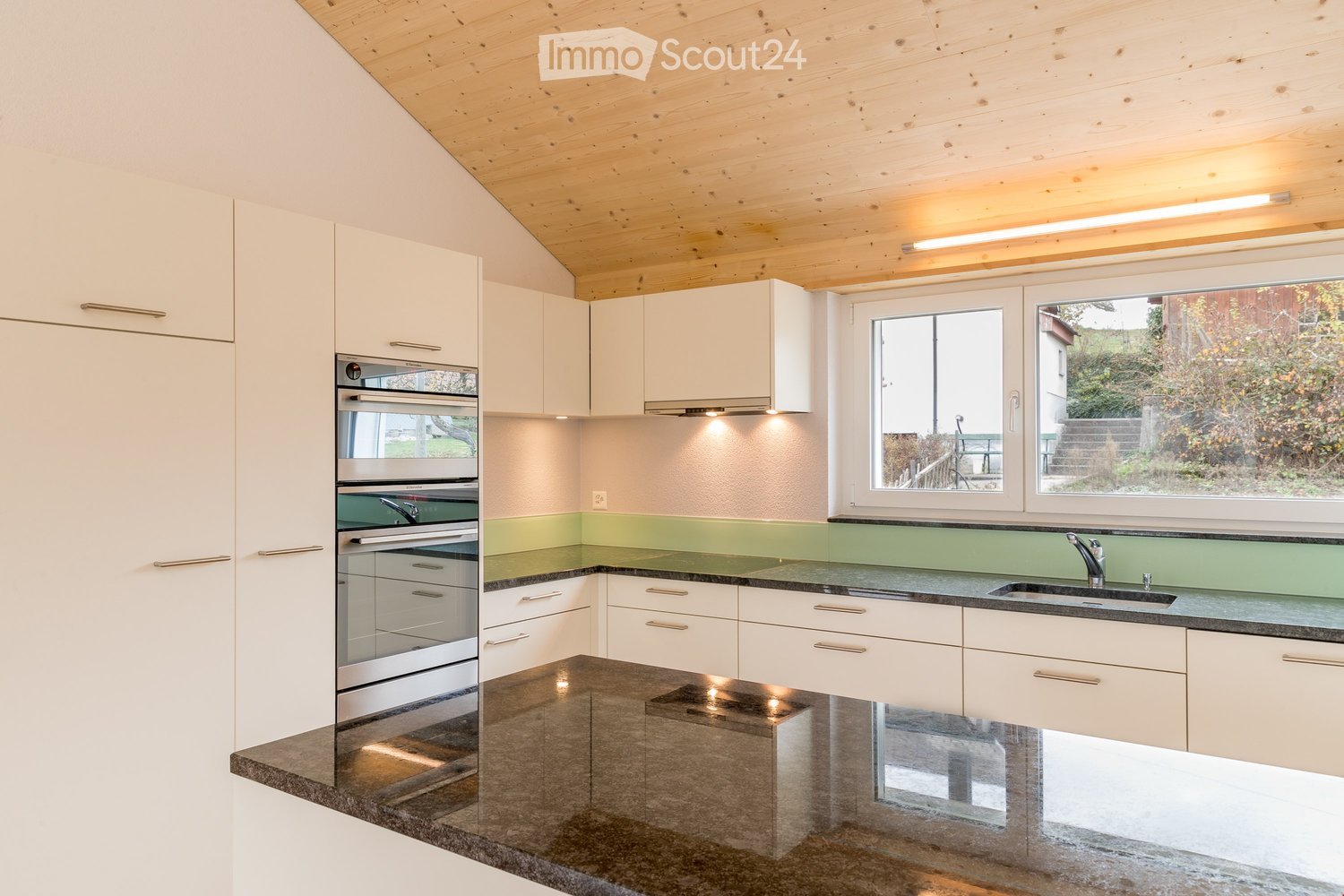 modern kitchen with white cabinets, granite countertops, stainless steel appliances, wooden ceiling, large window