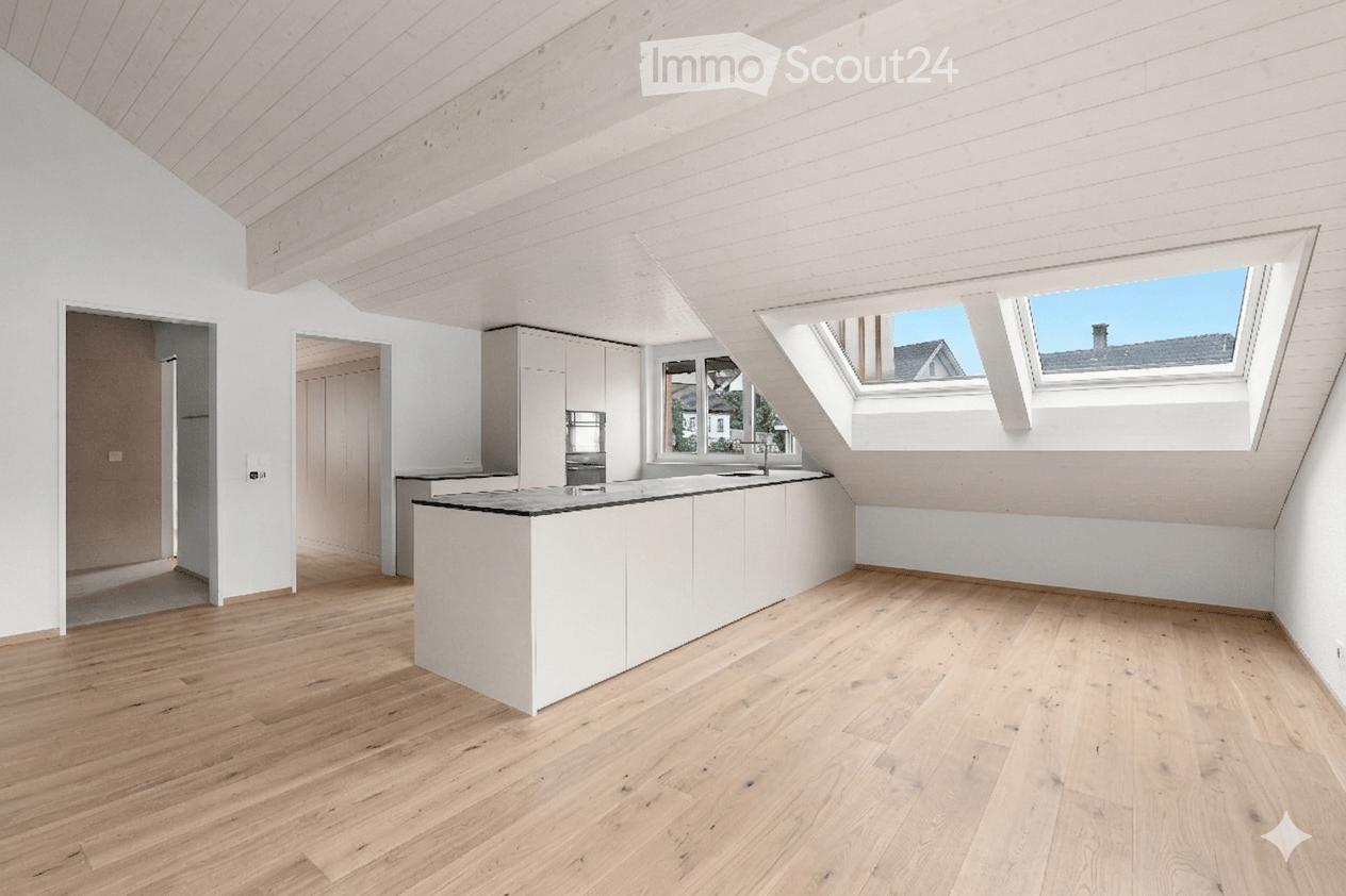 Bright, open kitchen with white cabinetry, a central island, wooden flooring, and skylight windows offering natural light and a view of the roof.