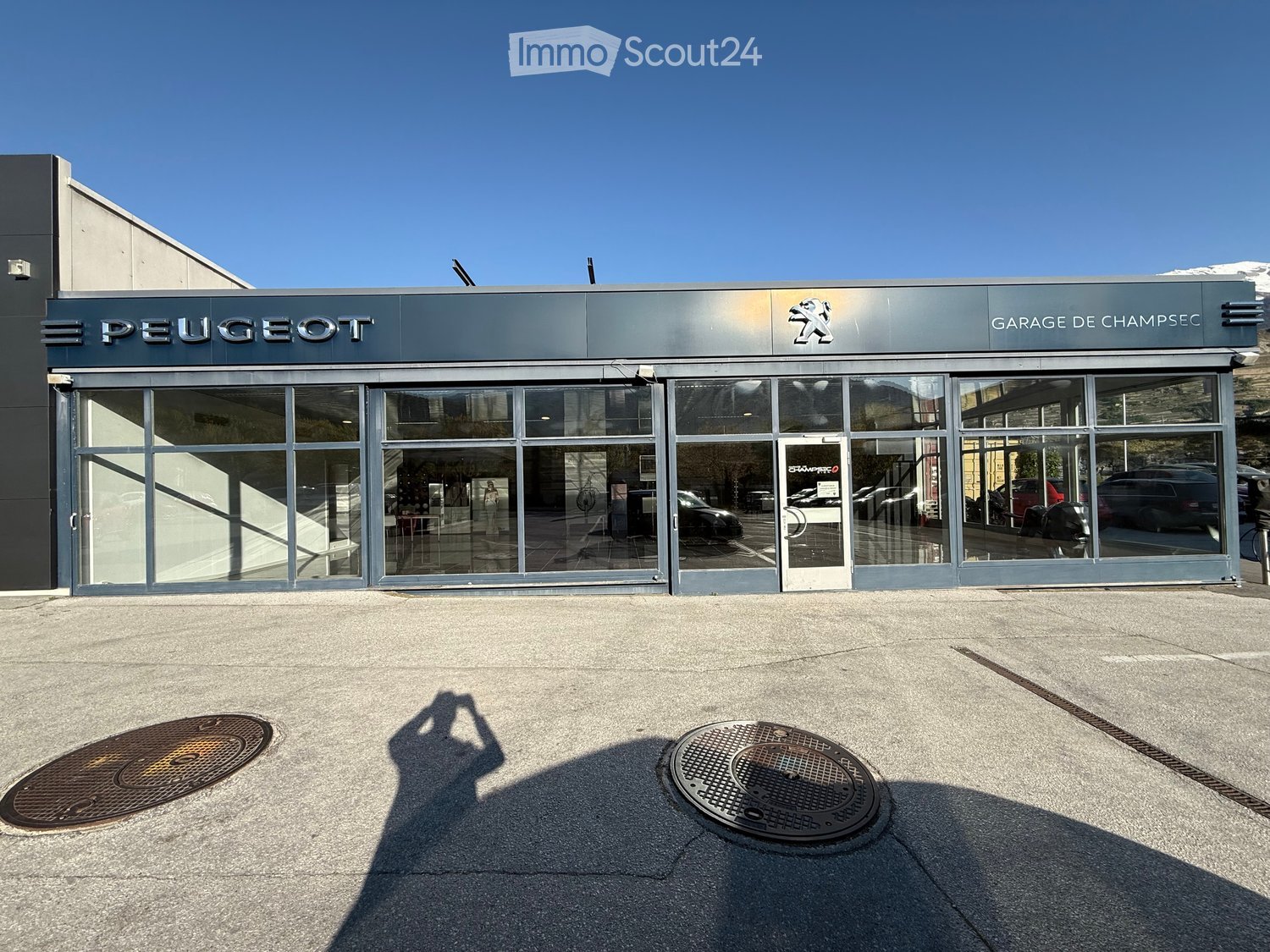 Building. Modern Peugeot car dealership building with large glass windows and a sleek metallic facade.