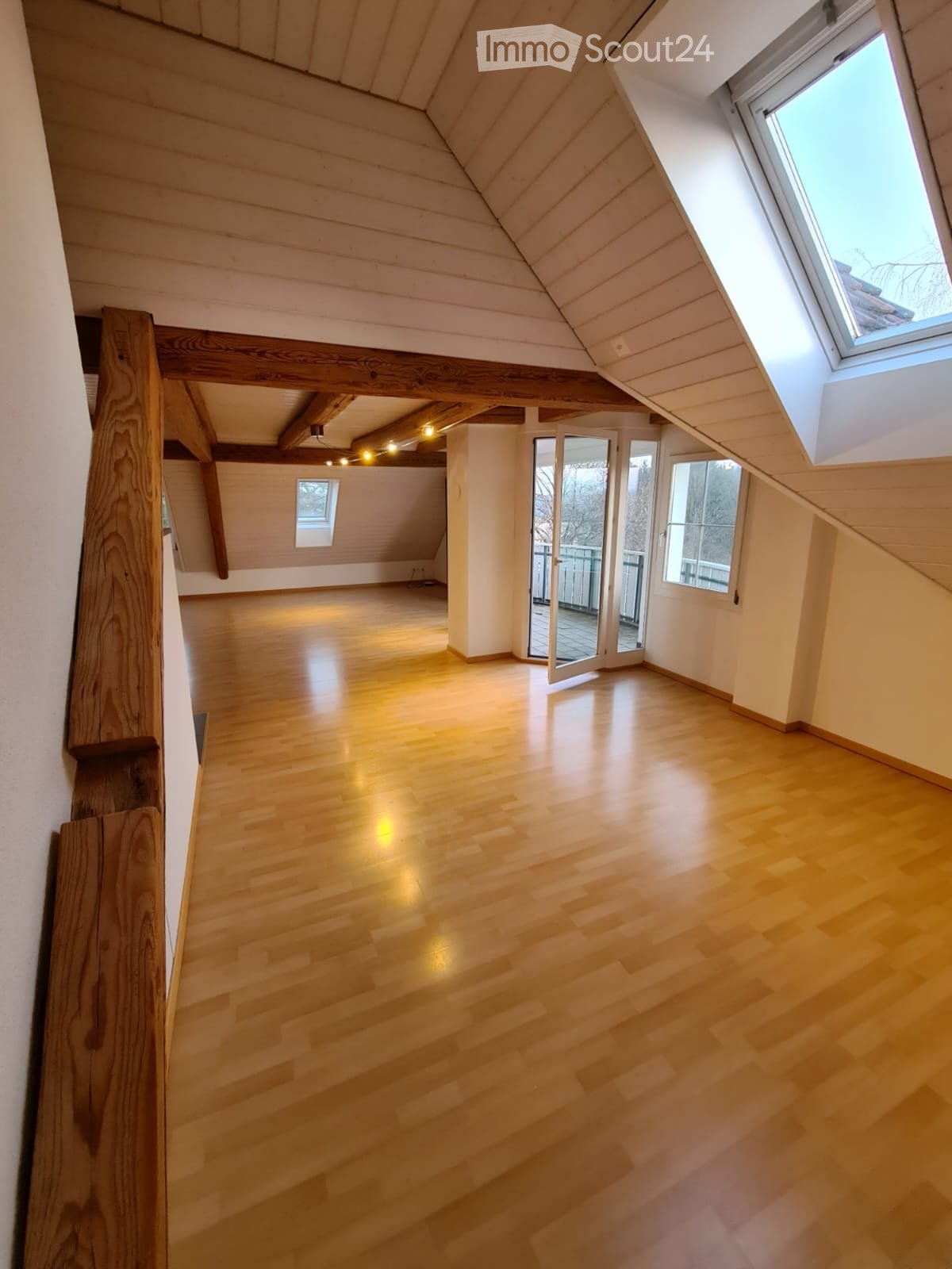 Unfurnished Room. Empty attic space with wooden floors, exposed wooden beams, and skylight windows. No furniture or equipment present.