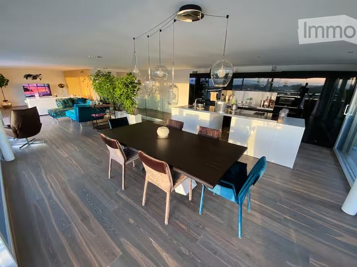 Furnished Room. Open-plan living and dining area with modern furniture, pendant lights, and a view through large windows.