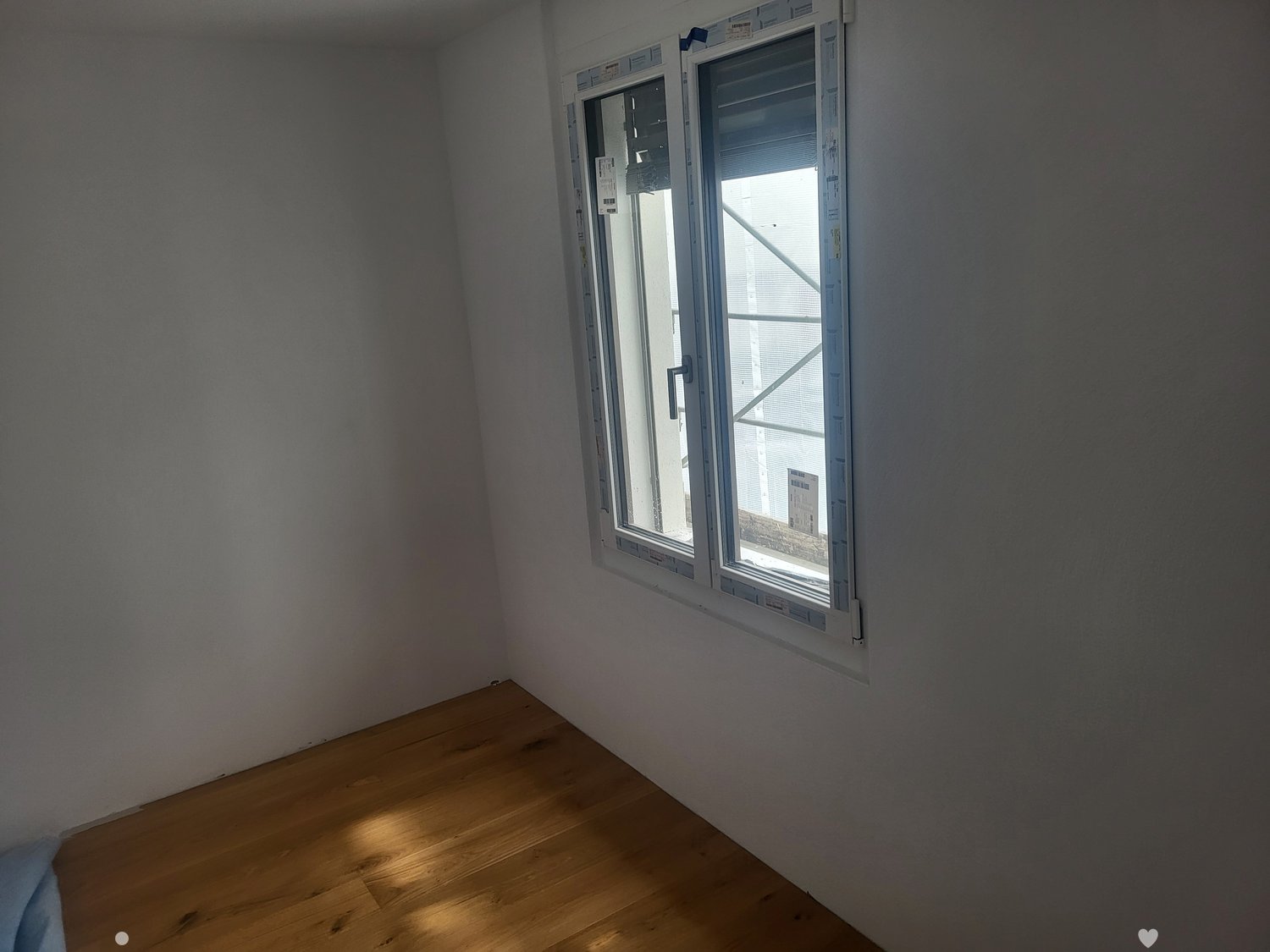 Unfurnished Room. Empty room with wooden flooring and a large window letting in natural light.