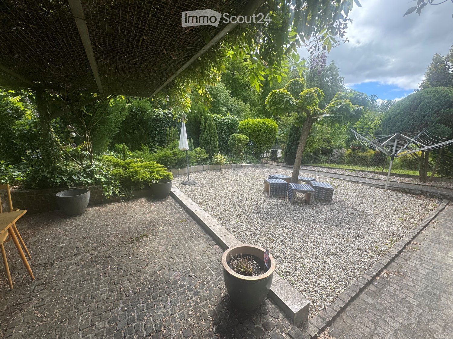 Garden / Outdoor Area. Garden area with gravel and brick pathways, potted plants, outdoor seating, and a covered pergola.