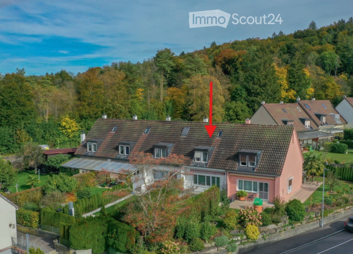 House. Aerial view of a two-story house with a red-tiled roof, surrounded by greenery and neighboring houses.