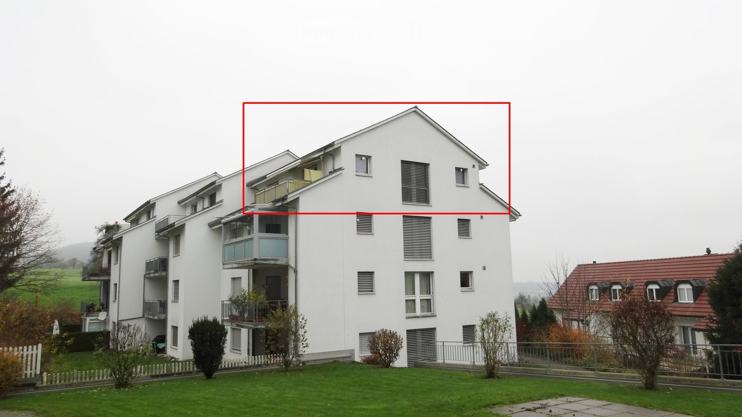 Building. Modern multi-story apartment building with white exterior, multiple balconies, and surrounding greenery.