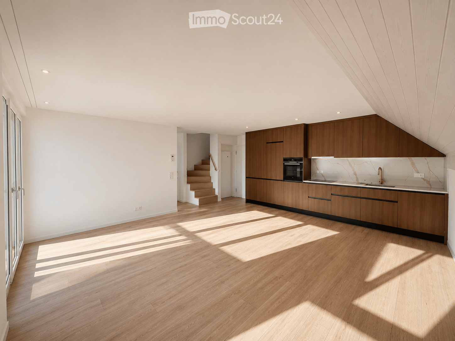 Modern kitchen with wooden cabinets, stainless steel oven, marble backsplash, and light wooden flooring.