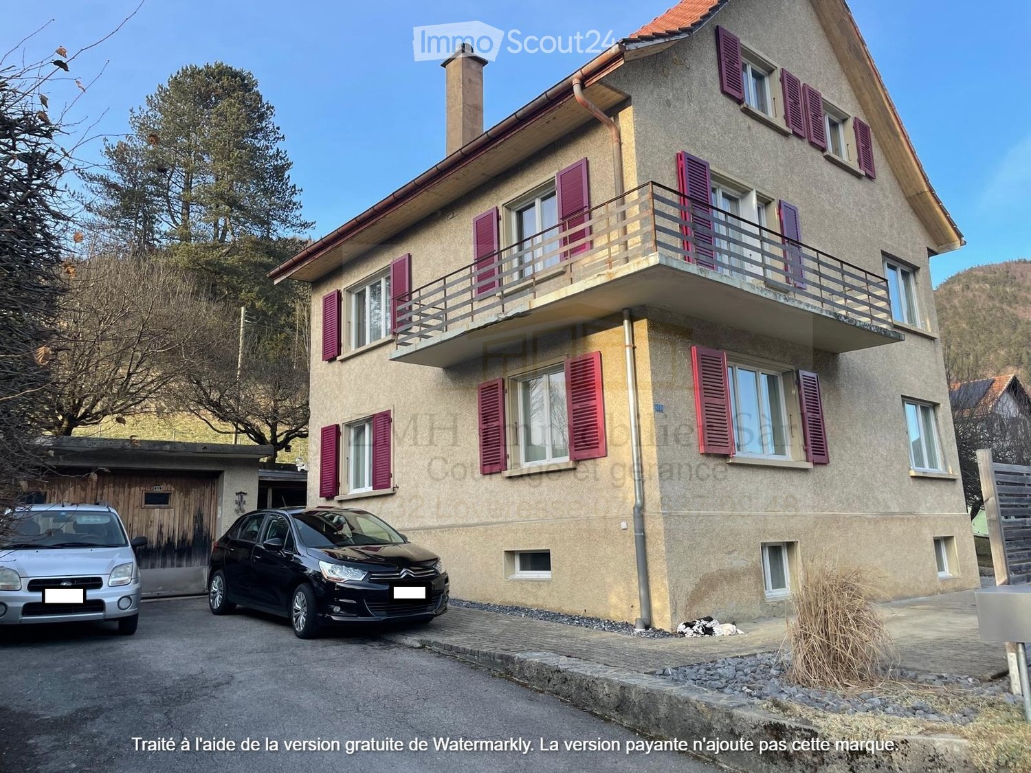 Three story house, red shutters, 2 car garage, small driveway, balcony