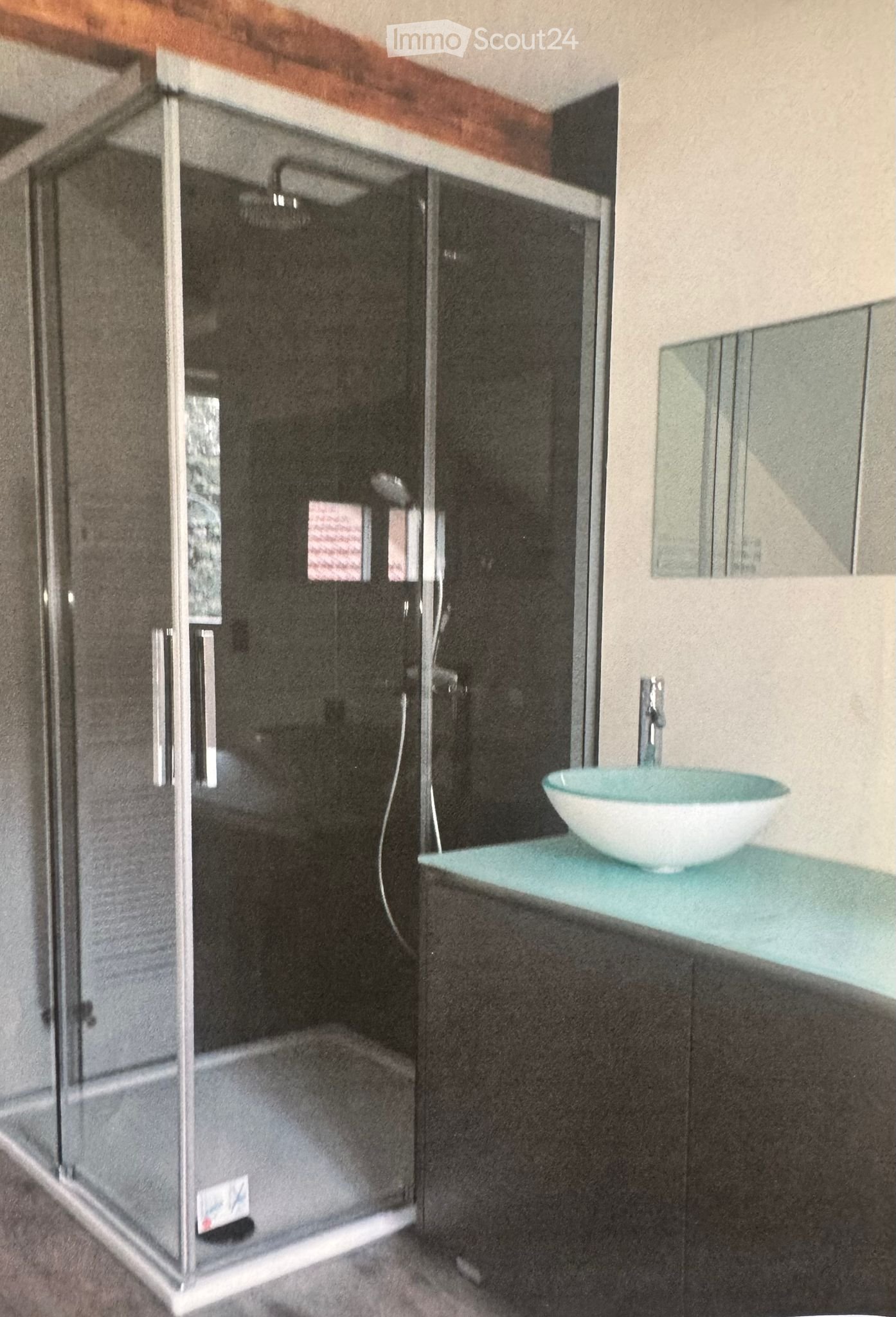 Modern bathroom with a glass-enclosed shower, a white sink with a turquoise countertop, and a mirror above the sink.