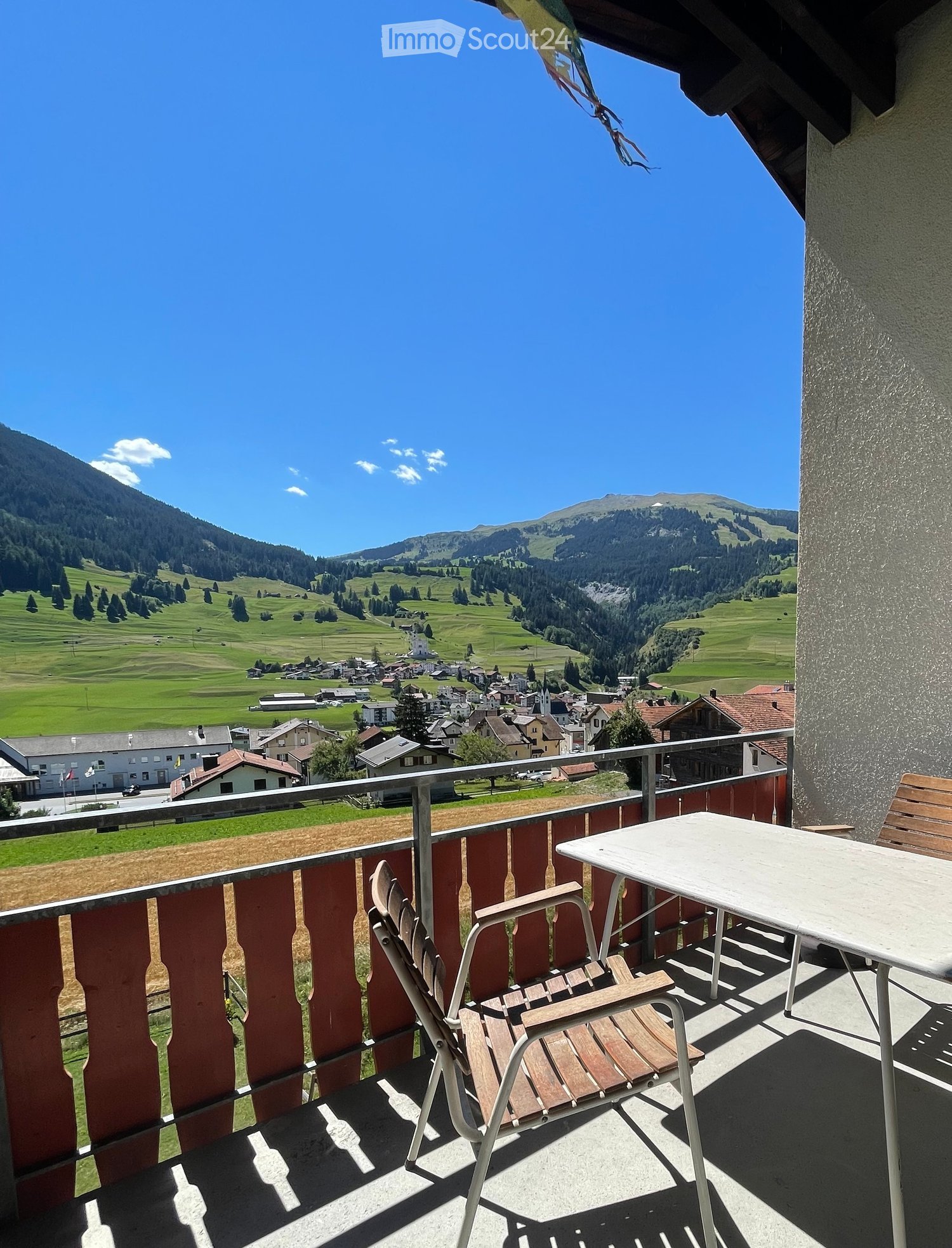 Balcony with a scenic mountain view, featuring a table and a chair.