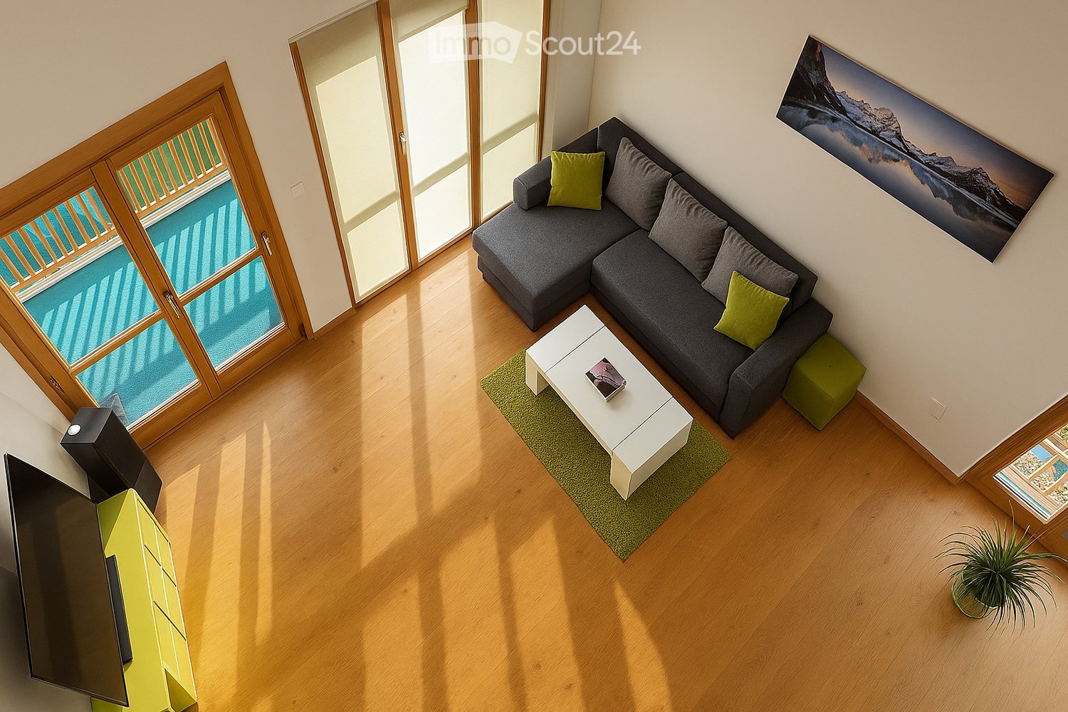 Modern living room with a grey sectional sofa, white coffee table, green rug, and large windows with wooden frames.