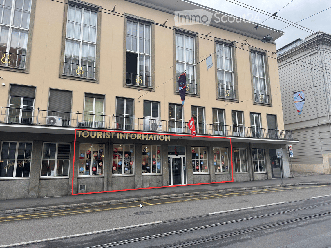 Multi-story building with large windows, a balcony, and a storefront labeled 'TOURIST INFORMATION' with promotional stickers on the windows.