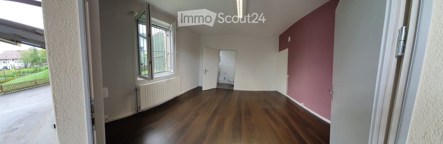 hardwood floors, white walls, pink wall, window with balcony, radiator, open door to hallway, open door to bathroom