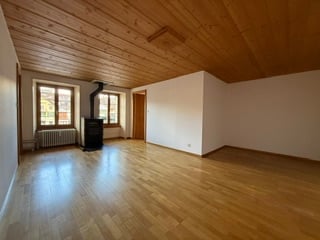 Unfurnished Room. Completely empty room with wooden floor, white walls, and a fireplace. No furniture or equipment.